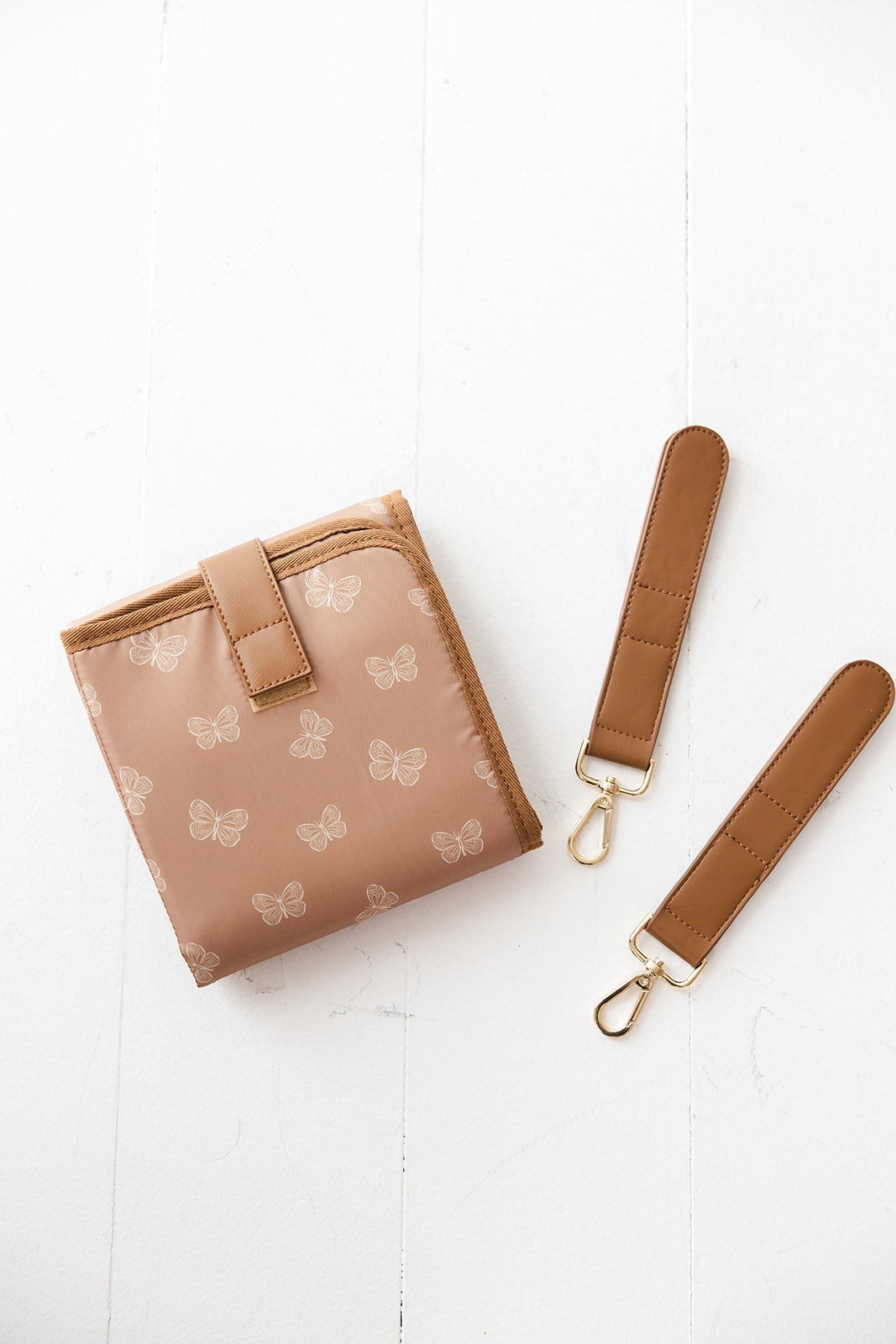Brown faux leather large diaper bag with checkered cross body strap, insulated bottle pockets, changing mat, and stroller straps.