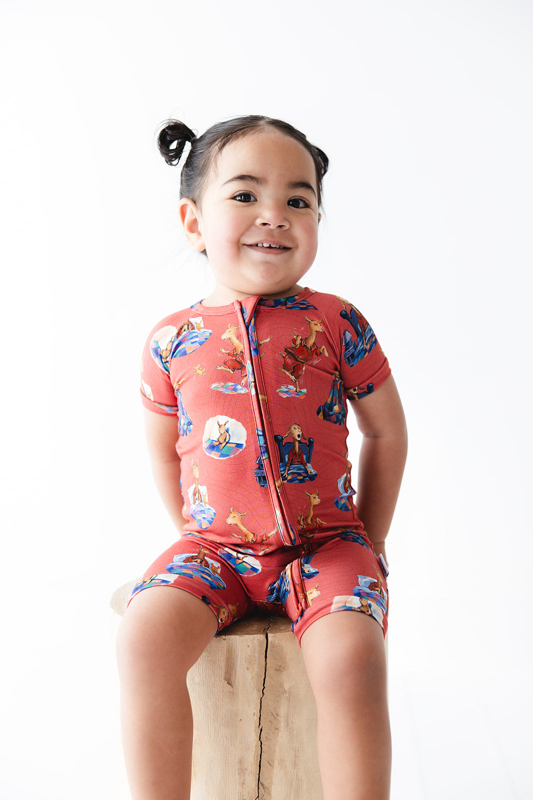 Bamboo double zipper shortie romper for babies and toddlers, both boys and girls. Print features a red background with Llama Llama Red Pajama.