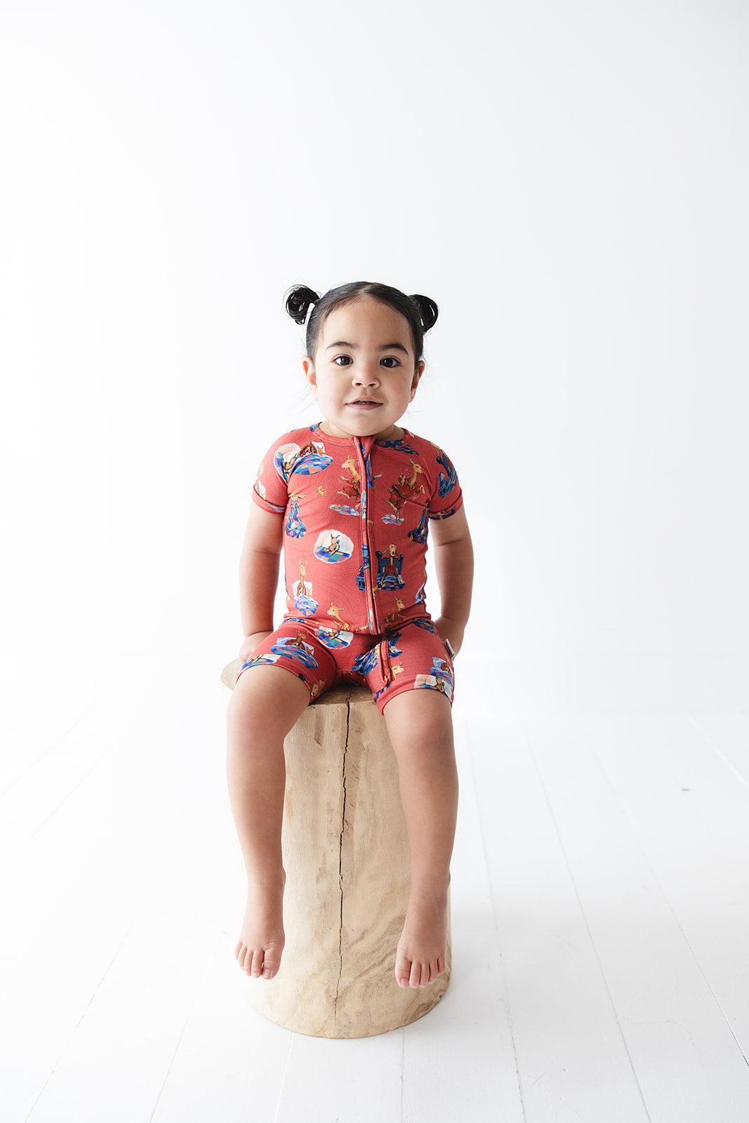 Bamboo double zipper shortie romper for babies and toddlers, both boys and girls. Print features a red background with Llama Llama Red Pajama.