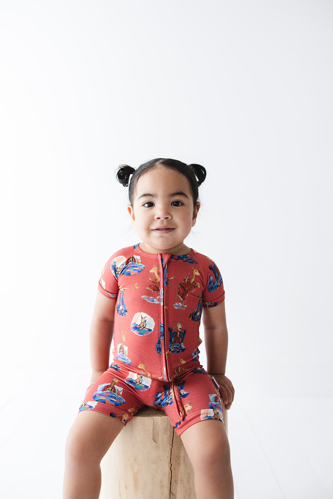 Bamboo double zipper shortie romper for babies and toddlers, both boys and girls. Print features a red background with Llama Llama Red Pajama.
