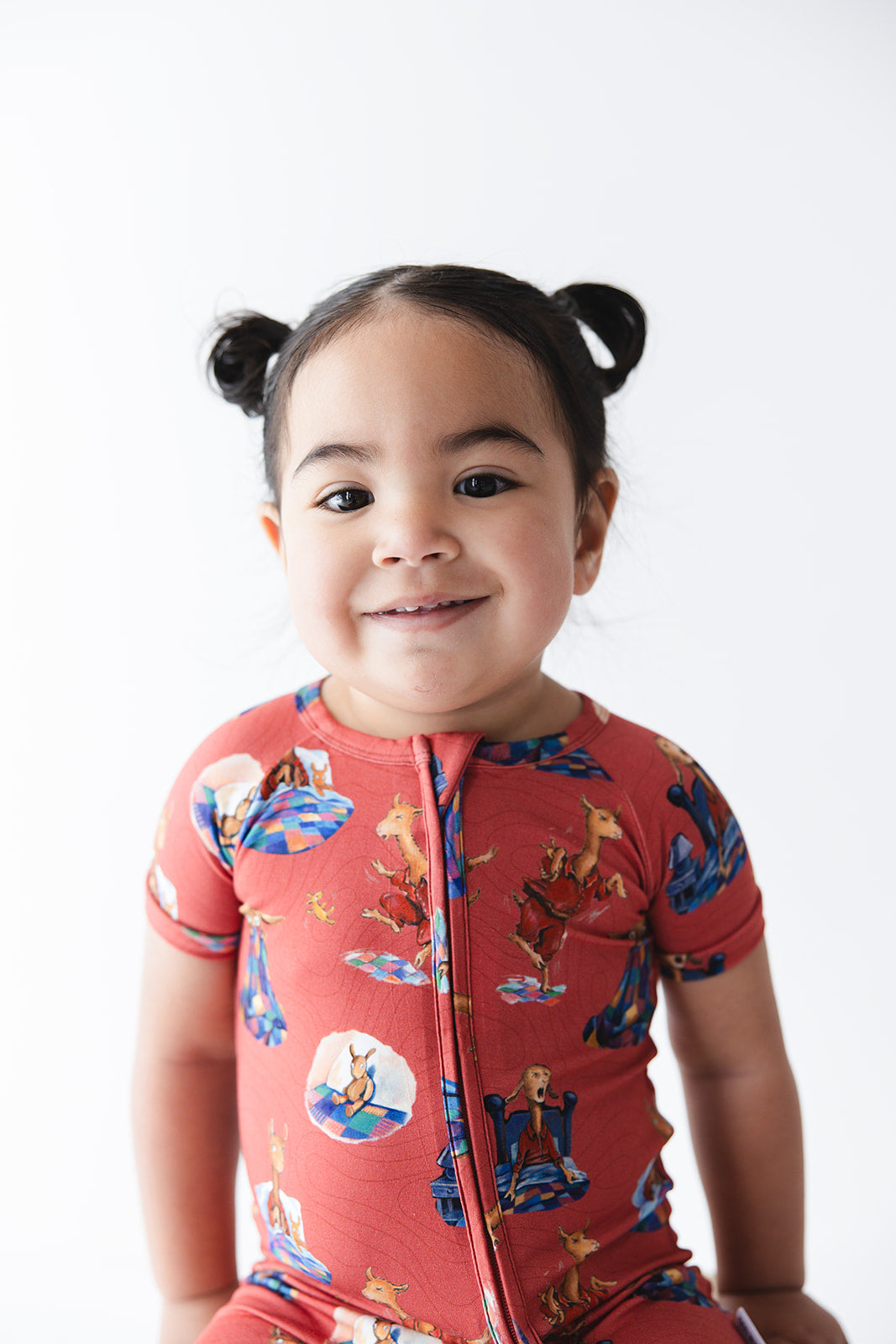 Bamboo double zipper shortie romper for babies and toddlers, both boys and girls. Print features a red background with Llama Llama Red Pajama.