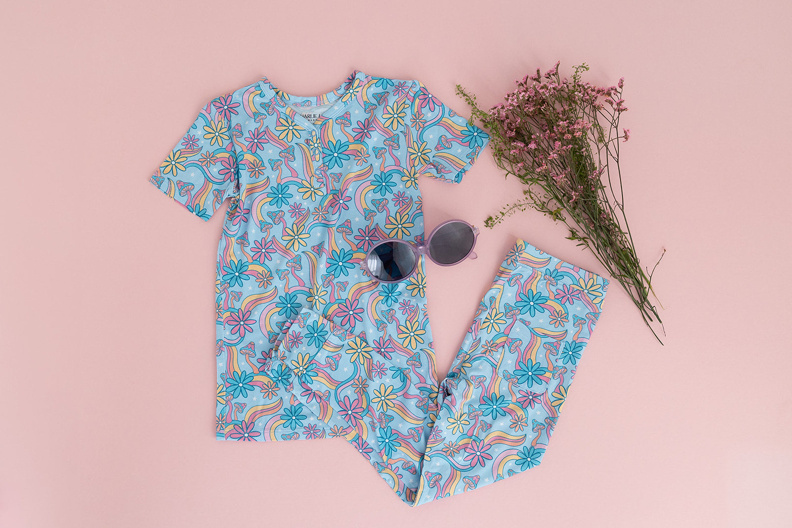 Bamboo pajama set for toddler girls in groovy, hippie, 70’s style print with mushrooms and florals on it. Button down collar and back pocket and the bamboo fabric is hypoallergenic, temperature regulating and is moisture wicking.