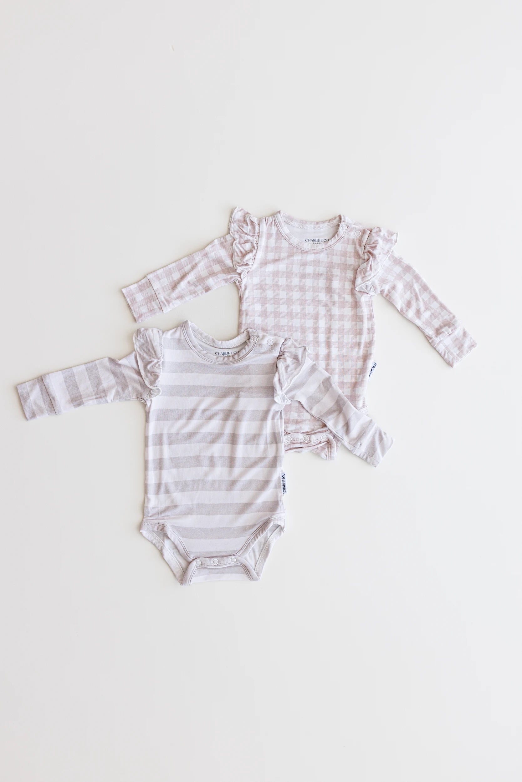 Ruffle bamboo bodysuit with crotch snaps and hand cuffs in neutral striped print for baby girls.