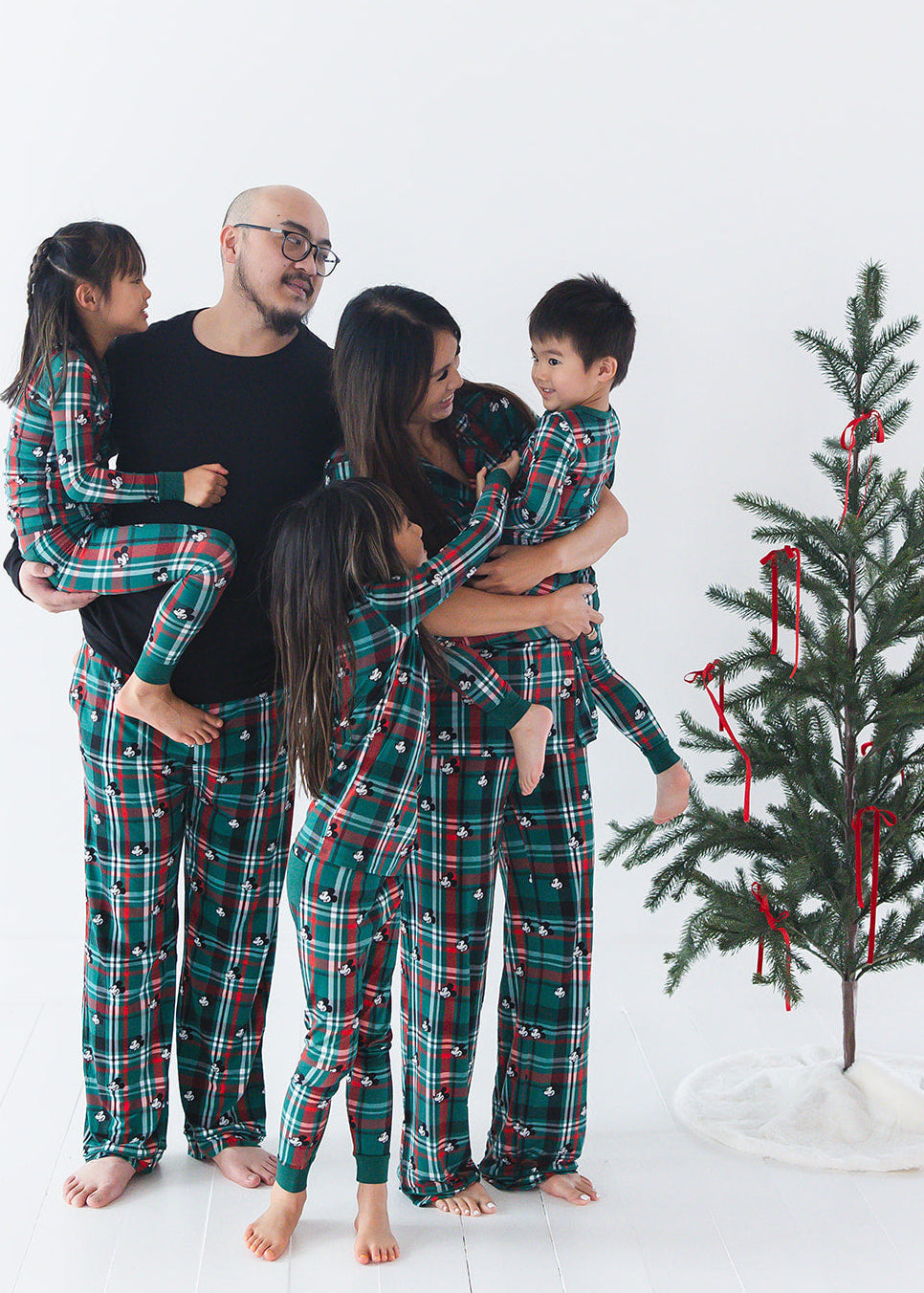 Family matching bamboo Christmas pajamas with Disney Mickey on green and red tartan print.