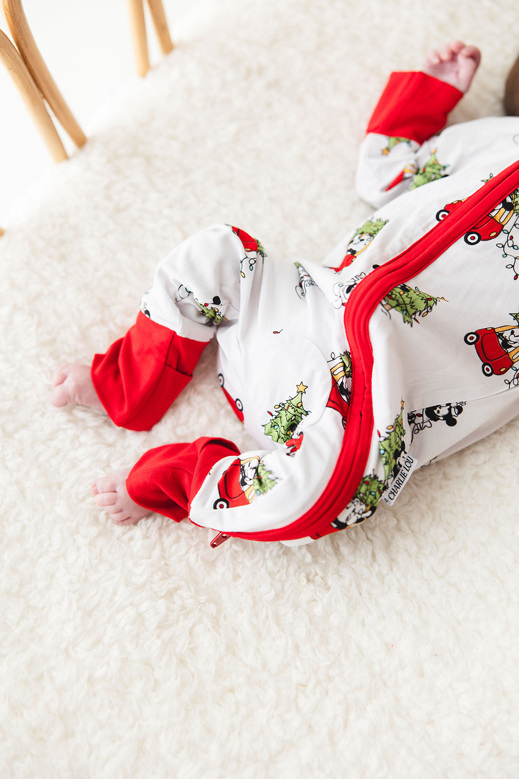 Gender-neutral convertible baby romper with hand and foot cuffs featuring a festive Steamboat Willie Christmas design with Minnie and Mickey Mouse. Includes a convenient double zipper for easy changes. Perfect for matching family Christmas pajamas.