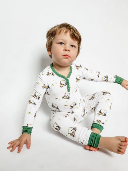 Gender neutral bamboo pajama set in golf sports print with green cuffs for toddler boys and girls.