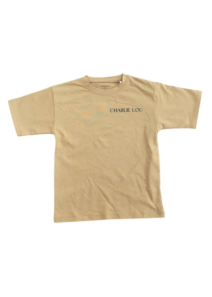 Skater style t-shirt for baby, toddler and little boys. Beige cotton shirt with a truck and palm tree graphic on the back. Soft, stretchy and thick fabric that is perfect for play with Charlie Lou Baby word logo on front.