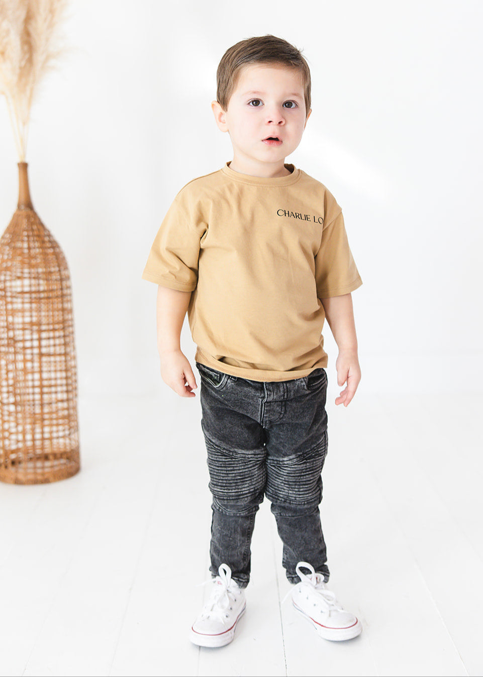 Skater style t-shirt for baby, toddler and little boys. Beige cotton shirt with a truck and palm tree graphic on the back. Soft, stretchy and thick fabric that is perfect for play with Charlie Lou Baby word logo on front.