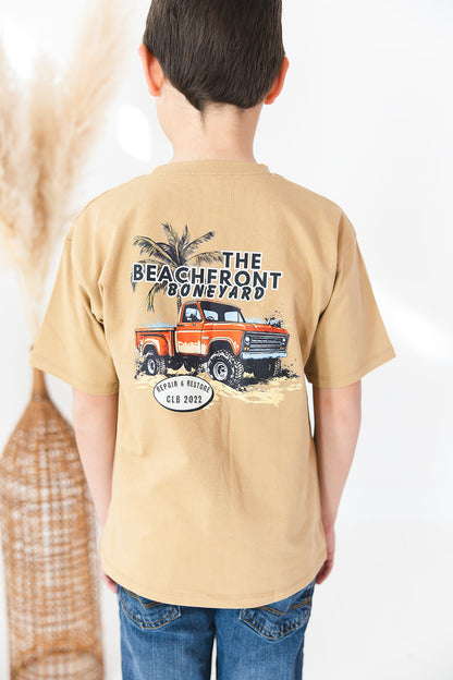 Skater style t-shirt for baby, toddler and little boys. Beige cotton shirt with a truck and palm tree graphic on the back. Soft, stretchy and thick fabric that is perfect for play with Charlie Lou Baby word logo on front.