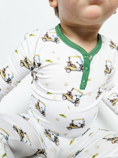 Gender neutral bamboo pajama set in golf sports print with green cuffs for toddler boys and girls.