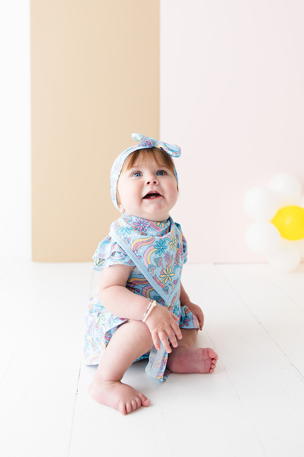 Groovy, hippie, 70’s print on a bamboo snap bib with terry cloth filling. Blue, pink and orange floral and mushroom bamboo bib for baby girls.