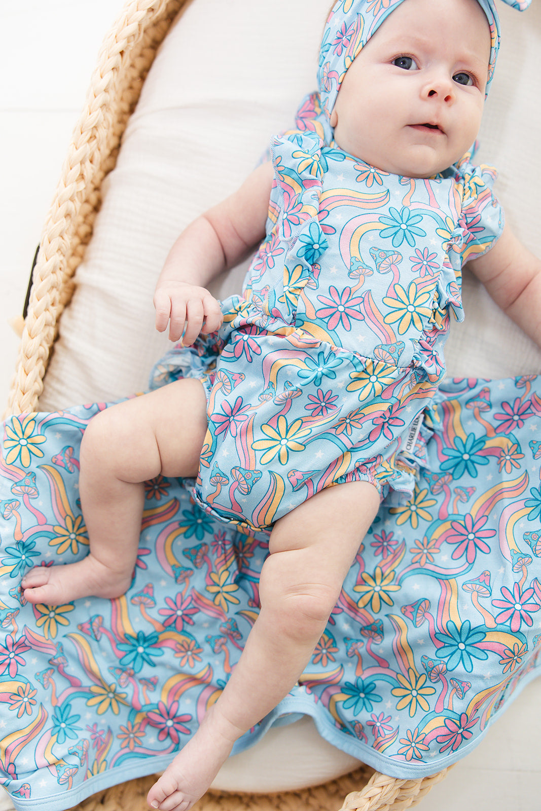 Bamboo bubble ruffle bodysuit with a groovy, hippie, 70’s style print that has florals and mushrooms on it for baby girls. This bamboo fabric has blues, pinks and oranges on it and is hypoallergenic, has UV protection and is temperature regulating. 