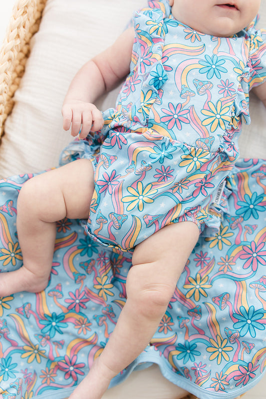 Bamboo bubble ruffle bodysuit with a groovy, hippie, 70’s style print that has florals and mushrooms on it for baby girls. This bamboo fabric has blues, pinks and oranges on it and is hypoallergenic, has UV protection and is temperature regulating. 