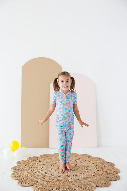 Bamboo pajama set for toddler girls in groovy, hippie, 70’s style print with mushrooms and florals on it. Button down collar and back pocket and the bamboo fabric is hypoallergenic, temperature regulating and is moisture wicking. 