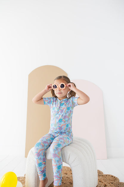 Bamboo pajama set for toddler girls in groovy, hippie, 70’s style print with mushrooms and florals on it. Button down collar and back pocket and the bamboo fabric is hypoallergenic, temperature regulating and is moisture wicking. 