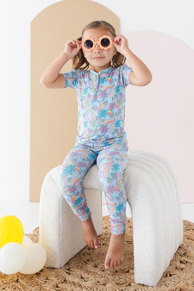 Bamboo pajama set for toddler girls in groovy, hippie, 70’s style print with mushrooms and florals on it. Button down collar and back pocket and the bamboo fabric is hypoallergenic, temperature regulating and is moisture wicking. 