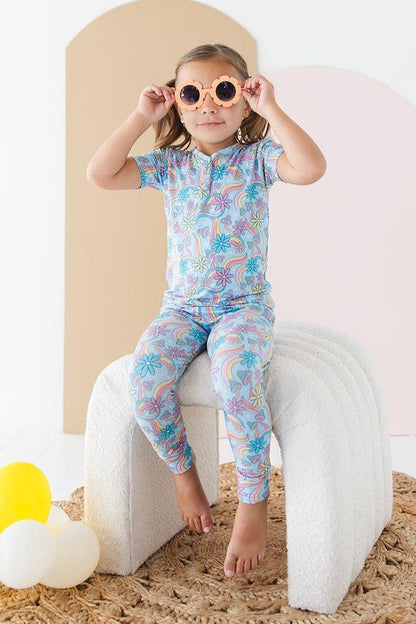 Bamboo pajama set for toddler girls in groovy, hippie, 70’s style print with mushrooms and florals on it. Button down collar and back pocket and the bamboo fabric is hypoallergenic, temperature regulating and is moisture wicking. 