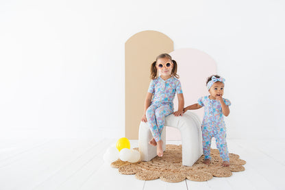 Bamboo pajama set for toddler girls in groovy, hippie, 70’s style print with mushrooms and florals on it. Button down collar and back pocket and the bamboo fabric is hypoallergenic, temperature regulating and is moisture wicking. 