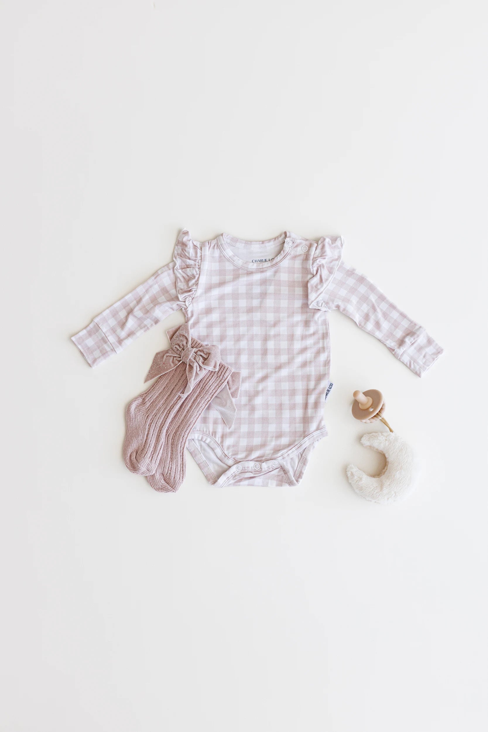 Ruffle bamboo bodysuit with crotch snaps and hand cuffs in peach and pink gingham.