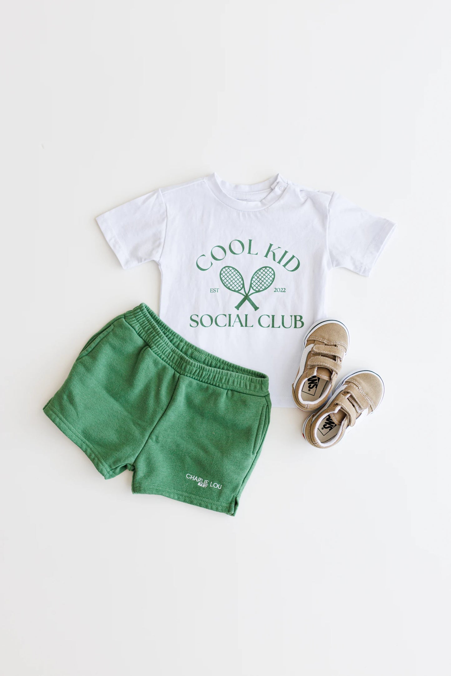 Cool Kid Club white T-Shirt with green graphic which is gender neutral for boys and girls with shoulder snaps.