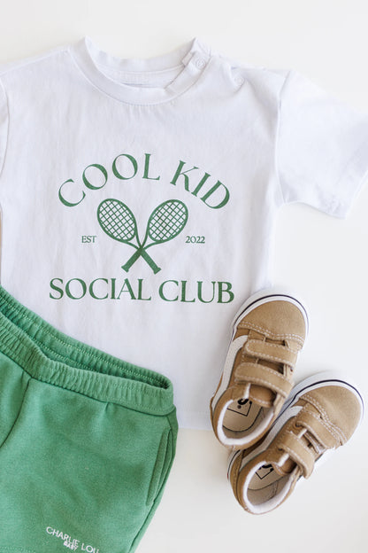 Cool Kid Club white T-Shirt with green graphic which is gender neutral for boys and girls with shoulder snaps.