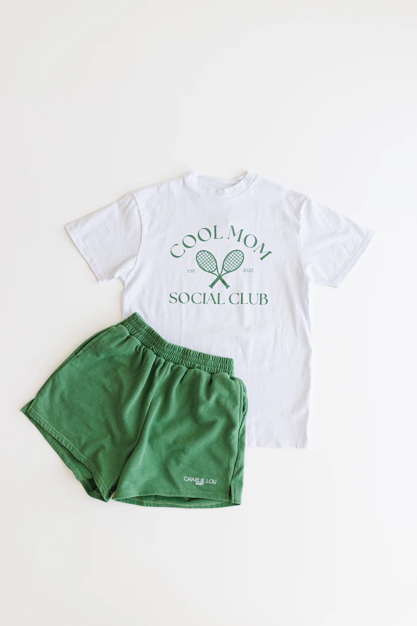 White women's t-shirt with green graphic that says Cool Mom Social Club in crew neck style.