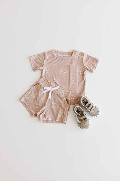 Bamboo shortie set with pockets, drawstring and shoulder snaps for boys and girls in Beige / Sand / Tan Smiley Face print.