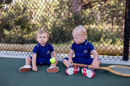 Preppy boys short sleeve polo romper with crotch snaps made from blue waffle bamboo & embroidered with Charlie Lou Baby Club.