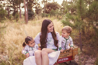 Gender neutral bamboo pajama set in golf sports print with green cuffs for toddler boys and girls.