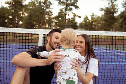 Gender neutral bamboo pajama set in golf sports print with green cuffs for toddler boys and girls.