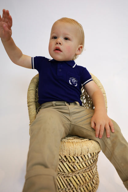 Preppy boys short sleeve polo romper with crotch snaps made from blue waffle bamboo & embroidered with Charlie Lou Baby Club.