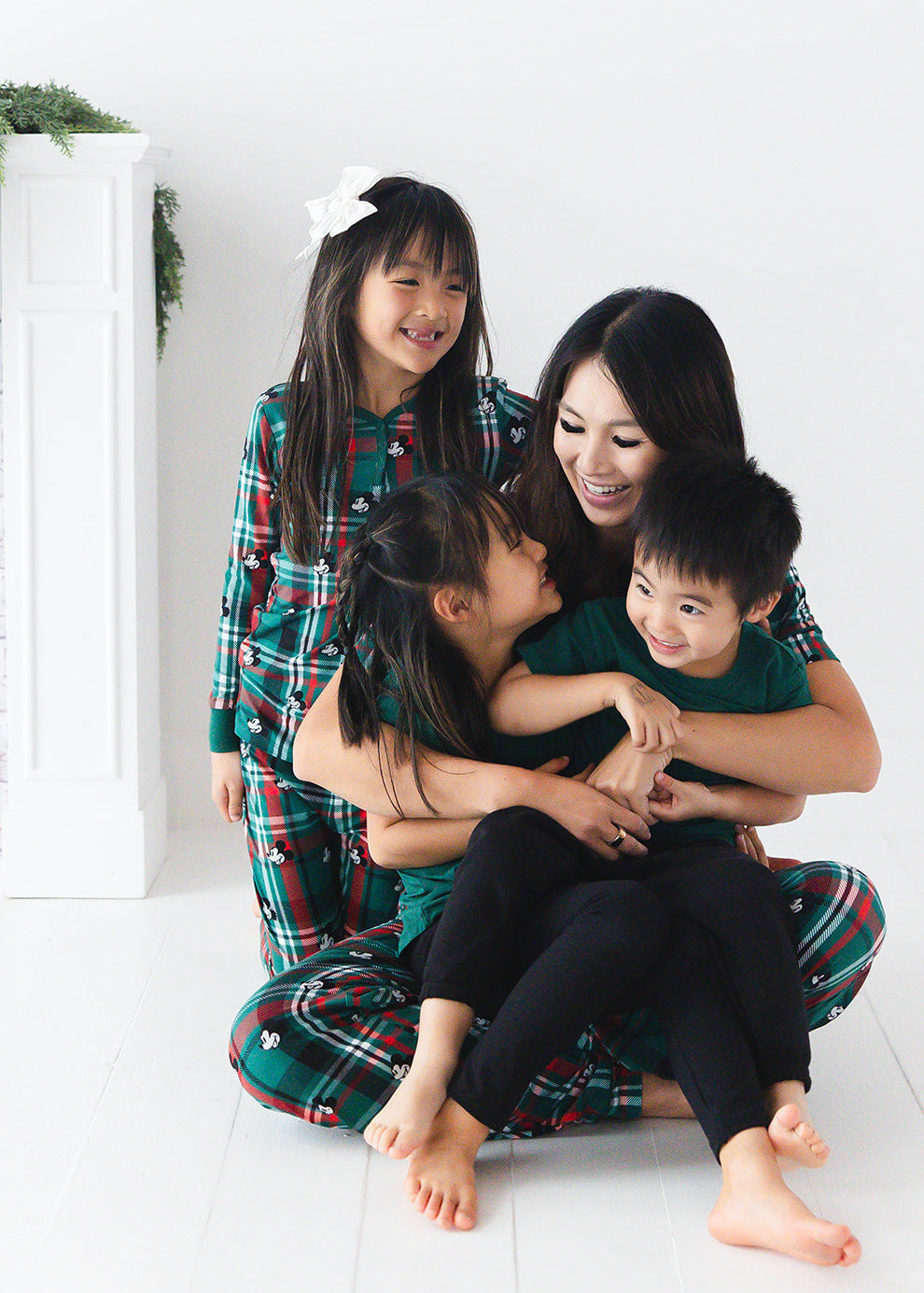 Family matching bamboo Christmas pajamas with Disney Mickey on green and red tartan print.