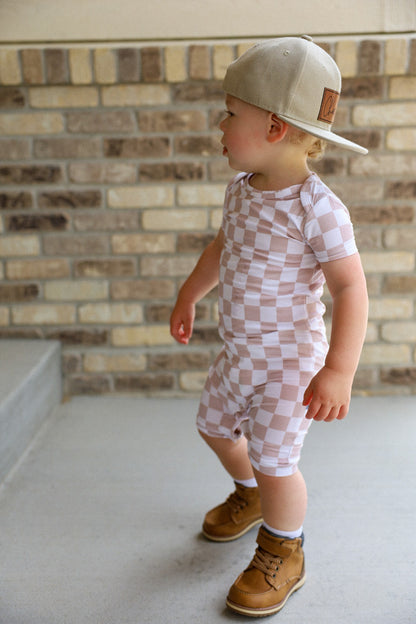 Gender neutral short sleeve romper with crotch snaps made from bamboo with neutral checkered print for boys and girls.