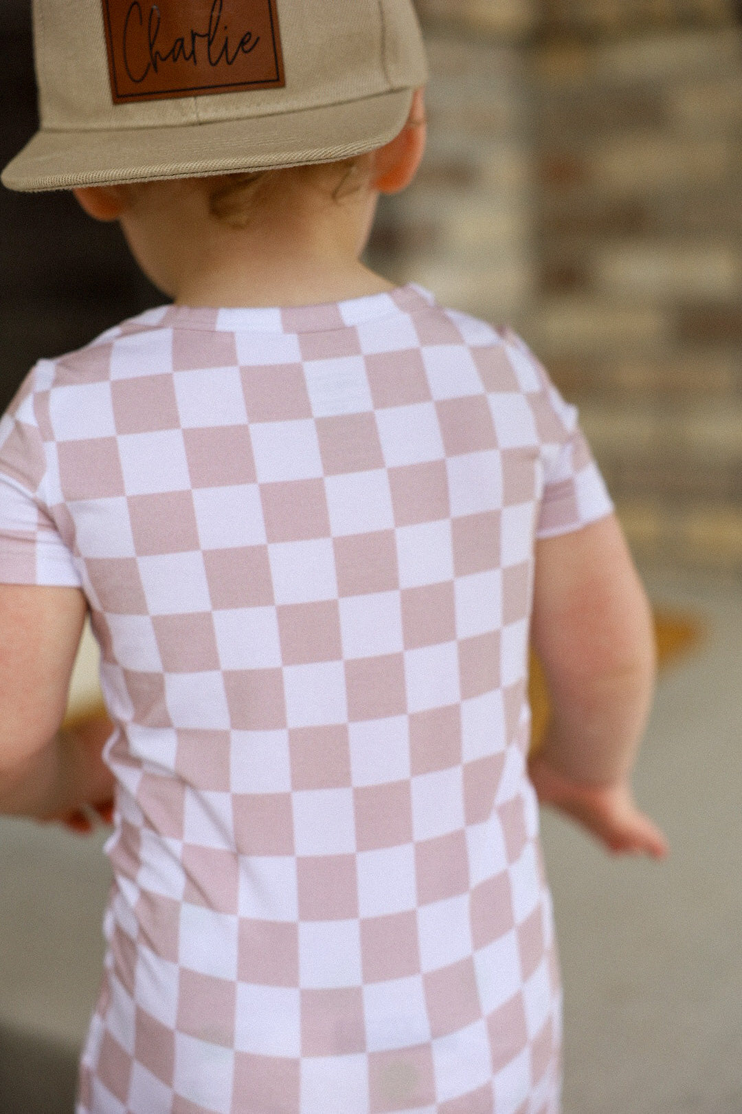 Gender neutral short sleeve romper with crotch snaps made from bamboo with neutral checkered print for boys and girls.