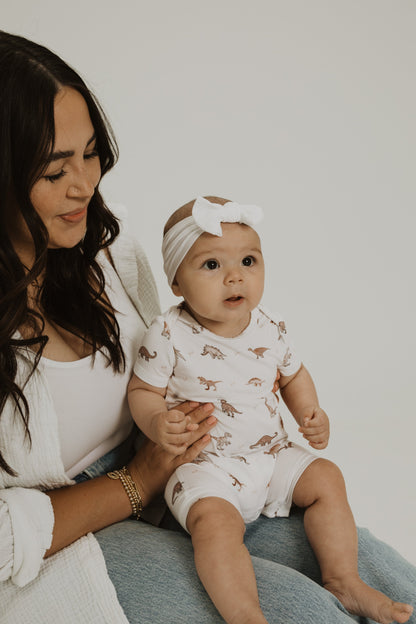 Gender neutral short sleeve romper with crotch snaps made from bamboo with neutral dinosaur print for boys and girls.