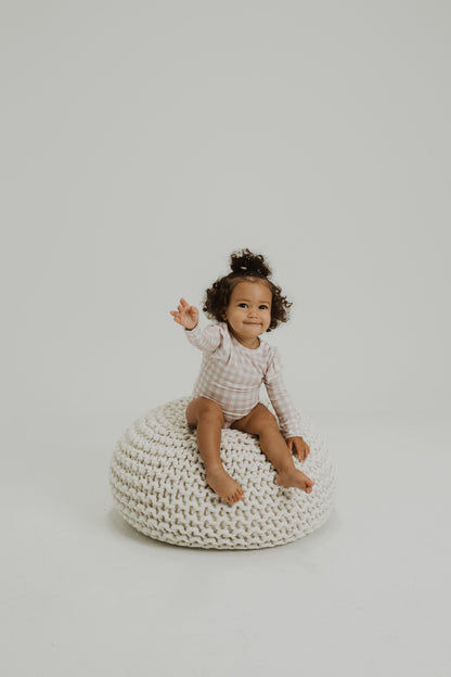 Ruffle bamboo bodysuit with crotch snaps and hand cuffs in peach and pink gingham.